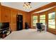 Home office featuring wood trim, a bay window, neutral carpet, and a modern light fixture at 8261 Twin Pointe Cir, Indianapolis, IN 46236