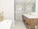 Bright, modern bathroom featuring double sinks, a large mirror, and a separate tub and shower at 8429 Catamaran Dr, Indianapolis, IN 46236