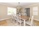 Light-filled dining room with a wooden table seating eight, a beaded chandelier, and large windows at 8429 Catamaran Dr, Indianapolis, IN 46236