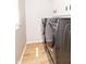 Modern laundry room featuring front load washer and dryer, sleek cabinets, and wood-look flooring at 8429 Catamaran Dr, Indianapolis, IN 46236