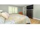 Tranquil main bedroom with wood-look floors, a mounted TV, and a glimpse of the ensuite bathroom at 8429 Catamaran Dr, Indianapolis, IN 46236
