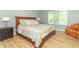 Comfortable main bedroom with wood-look floors, a king-sized bed, and plenty of natural light from a window at 8429 Catamaran Dr, Indianapolis, IN 46236
