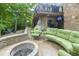 Beautiful stone patio with comfortable green seating, fire pit, and entertainment area with TV at 8429 Catamaran Dr, Indianapolis, IN 46236