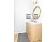 Charming powder room featuring a light wood vanity, round mirror, and stylish black and white rug at 8429 Catamaran Dr, Indianapolis, IN 46236