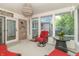 Cozy sunroom with bright red seating, glass windows, and access to the outdoor patio and garden at 8429 Catamaran Dr, Indianapolis, IN 46236