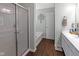 Bright bathroom features an enclosed glass shower, soaking tub, white cabinets, and wood look floors at 8720 N Deer Crossing Blvd, McCordsville, IN 46055