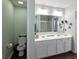 Well-lit bathroom features a large vanity with double sinks, white cabinets and dark brown floors at 8720 N Deer Crossing Blvd, McCordsville, IN 46055