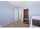 Light blue bedroom with a crib, bookshelf and neutral carpet at 8720 N Deer Crossing Blvd, McCordsville, IN 46055