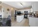 Well-appointed kitchen boasts white cabinetry, granite countertops, and modern black appliances, complemented by a functional island at 8720 N Deer Crossing Blvd, McCordsville, IN 46055