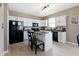 Modern kitchen features white cabinets, black appliances, a kitchen island with seating, and light hardwood style flooring at 8720 N Deer Crossing Blvd, McCordsville, IN 46055