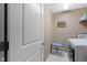 Neutral laundry room with modern washer and dryer, shelving and a 'HOME' decoration at 8720 N Deer Crossing Blvd, McCordsville, IN 46055
