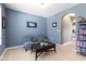 Stylish living room with blue walls, comfortable seating, and built-in shelving, creating a perfect reading nook at 8720 N Deer Crossing Blvd, McCordsville, IN 46055