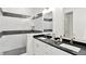 Bright bathroom featuring a double sink vanity with black countertop and elegant shower with black and white tiling at 920 Veterans Way # 204, Carmel, IN 46032
