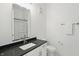 Bathroom with marble flooring, toilet, vanity with black countertop, and shower at 920 Veterans Way # 204, Carmel, IN 46032