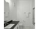 Well-lit bathroom with marble flooring, toilet, and a vanity with a black countertop at 920 Veterans Way # 204, Carmel, IN 46032