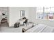 Sunlit bedroom featuring a workspace with a large window, desk, chair, and a view of neighboring rooftops at 920 Veterans Way # 204, Carmel, IN 46032