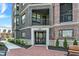 Elegant brick building entrance with black framed windows and door; charming outdoor benches at 920 Veterans Way # 204, Carmel, IN 46032