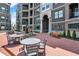 Relaxing courtyard with tables, chairs, benches, and fountain surrounded by elegant brick apartment buildings at 920 Veterans Way # 204, Carmel, IN 46032
