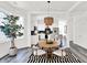 Cozy dining area with a round table, statement lighting, and a view of the modern kitchen with sleek appliances at 920 Veterans Way # 204, Carmel, IN 46032