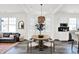 Bright dining area featuring a round table, modern lighting, and an open layout to the living spaces at 920 Veterans Way # 204, Carmel, IN 46032
