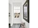 Bright hallway features a window with a view, light gray walls, and a rustic wooden bench at 920 Veterans Way # 204, Carmel, IN 46032