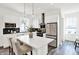 Modern kitchen with white cabinetry, black backsplash, stainless steel appliances, and an island with seating for casual dining at 920 Veterans Way # 204, Carmel, IN 46032