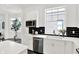Well-lit kitchen with white cabinets, black backsplash, stainless steel appliances, and contemporary finishes, offering style and functionality at 920 Veterans Way # 204, Carmel, IN 46032