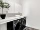Modern laundry room with front load washer and dryer, white countertops, and ample storage at 920 Veterans Way # 204, Carmel, IN 46032