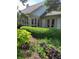 Backyard showcasing lush garden beds with a variety of plants and shrubs, alongside a home's exterior with doors and windows at 9229 Tamarack Dr, Indianapolis, IN 46260