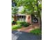 Charming home featuring a brick facade, striped awning, and landscaped garden leading to the front door at 9229 Tamarack Dr, Indianapolis, IN 46260