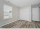 This bedroom features neutral paint, wood-look flooring, a window, and a closet at 10420 Day Star Dr, Indianapolis, IN 46234