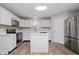 Bright kitchen with white cabinets, stainless steel appliances, kitchen island and wood-look floors at 10420 Day Star Dr, Indianapolis, IN 46234