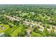 A bird's-eye perspective reveals a neighborhood with houses, green lawns, and mature trees at 10444 Indian Lake N Blvd, Indianapolis, IN 46236