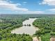 An aerial view showcases a serene lake surrounded by lush trees providing a sense of natural beauty at 10444 Indian Lake N Blvd, Indianapolis, IN 46236