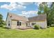 A spacious backyard with a wooden deck, lush green lawn, and mature trees provides outdoor living at 10444 Indian Lake N Blvd, Indianapolis, IN 46236