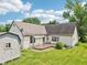 The backyard features a well-maintained lawn, mature trees, a storage shed, and a cozy wooden deck at 10444 Indian Lake N Blvd, Indianapolis, IN 46236