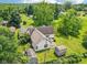 The aerial view captures a spacious backyard, a wooden deck, multiple storage sheds, and mature trees at 10444 Indian Lake N Blvd, Indianapolis, IN 46236
