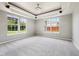Spacious carpeted bedroom features tray ceiling, chandelier and large windows providing ample natural light at 10444 Indian Lake N Blvd, Indianapolis, IN 46236