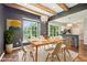 Elegant dining room with wood beams, chandelier, and views of the outdoor living space at 10444 Indian Lake N Blvd, Indianapolis, IN 46236