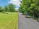 The property is accessed by a long driveway and features a well-maintained lawn and beautiful mature trees at 10444 Indian Lake N Blvd, Indianapolis, IN 46236