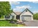 Charming white brick home featuring a two-car garage, lush landscaping, and welcoming curb appeal at 10444 Indian Lake N Blvd, Indianapolis, IN 46236