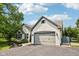 Charming white brick home featuring a two-car garage, lush landscaping, and welcoming curb appeal at 10444 Indian Lake N Blvd, Indianapolis, IN 46236