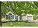 Lovely white brick home showcasing beautiful landscaping, arched window, and charming curb appeal at 10444 Indian Lake N Blvd, Indianapolis, IN 46236