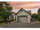 Beautiful white brick home showcasing an attached two-car garage and a serene sunset backdrop at 10444 Indian Lake N Blvd, Indianapolis, IN 46236