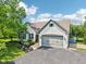Two-story white brick home featuring an attached garage, manicured lawn, and well-maintained landscaping at 10444 Indian Lake N Blvd, Indianapolis, IN 46236