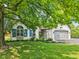A well maintained white brick home featuring dark shutters, an attached garage, and a lush front lawn at 10444 Indian Lake N Blvd, Indianapolis, IN 46236