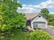 A beautifully landscaped front yard with a two-story white brick home and attached garage enhances curb appeal at 10444 Indian Lake N Blvd, Indianapolis, IN 46236