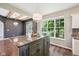 The kitchen features an island with granite countertop, chandelier, and a large window with a view to the backyard at 10444 Indian Lake N Blvd, Indianapolis, IN 46236