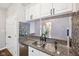 Kitchen sink with stainless steel appliances, granite countertops, mosaic backsplash, and open view to the living room at 10444 Indian Lake N Blvd, Indianapolis, IN 46236