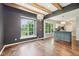 Open concept living room with hardwood floors, beamed ceiling, decorative lighting, and view of the kitchen island at 10444 Indian Lake N Blvd, Indianapolis, IN 46236